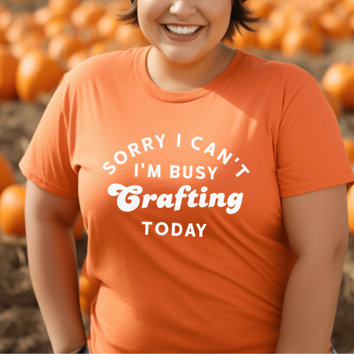 Person wearing an orange shirt with a pumpkin patch background