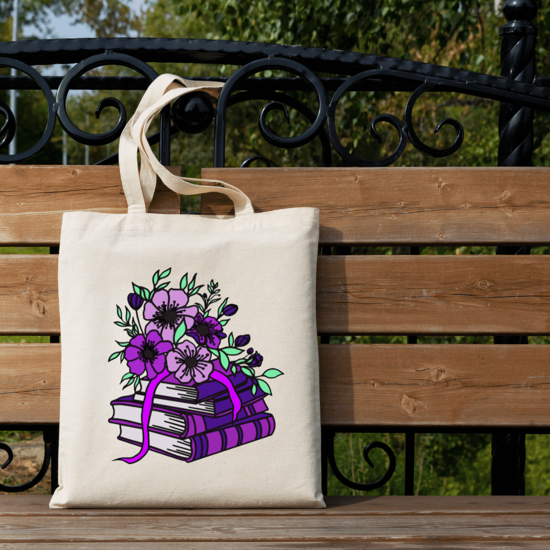 Tote bag with floral and book design on a wooden bench outdoors