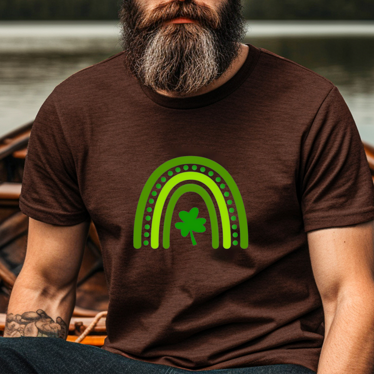 A stylized rainbow design with curved green stripes in varying shades, featuring a shamrock or clover at the center. The rainbow has dotted details between the arches, creating a festive St. Patrick's Day themed graphic.
