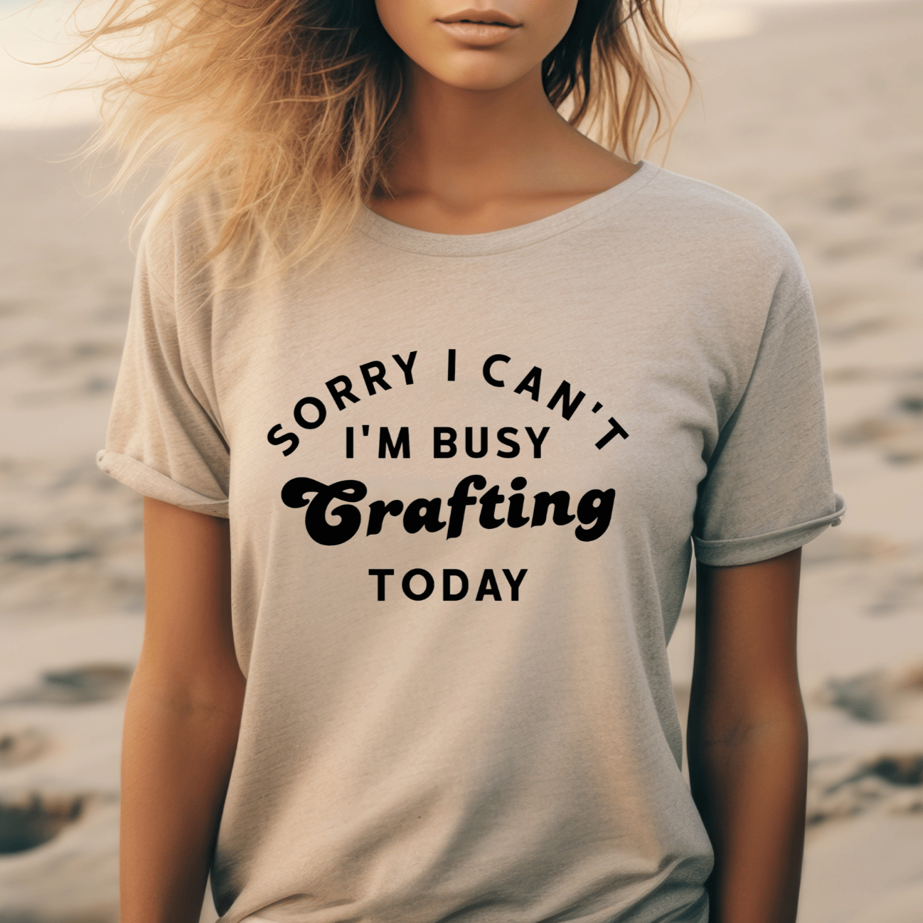 Woman wearing a t-shirt with 'Sorry I Can't I'm Busy Crafting Today' text on a beach.