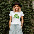 A stylized rainbow design with curved green stripes in varying shades, featuring a shamrock or clover at the center. The rainbow has dotted details between the arches, creating a festive St. Patrick's Day themed graphic.