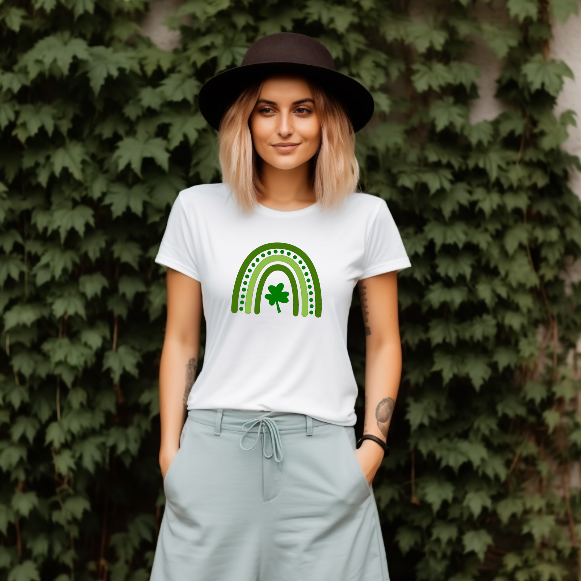 A stylized rainbow design with curved green stripes in varying shades, featuring a shamrock or clover at the center. The rainbow has dotted details between the arches, creating a festive St. Patrick's Day themed graphic.