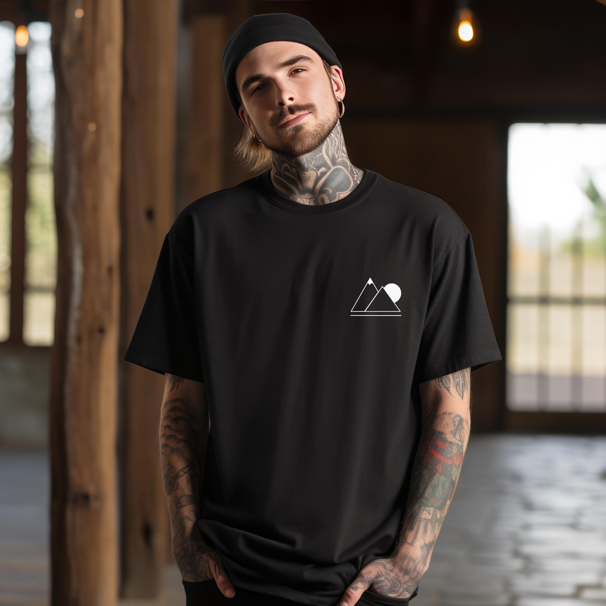 A person wearing a black t-shirt with a simple geometric mountain silhouette on the front.