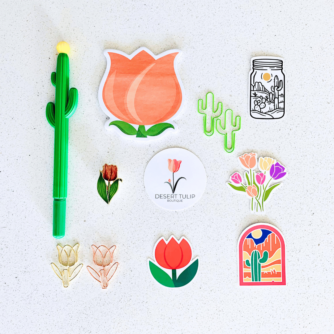Collection of desert cactus and tulip themed stickers, pen, paper pad, and enamel pin.
