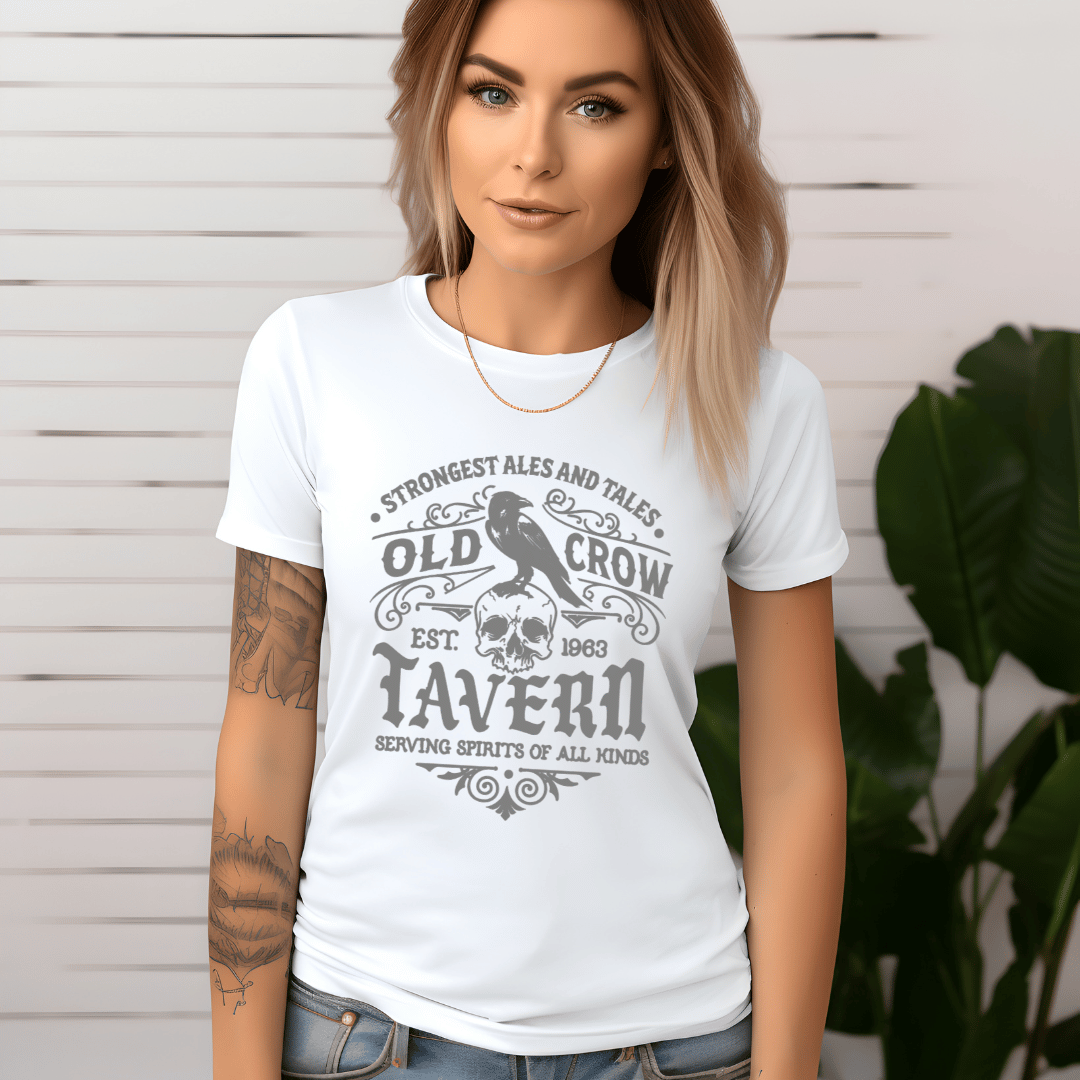 Woman wearing a white t-shirt with 'Old Crow Tavern' design against a light wooden panel background