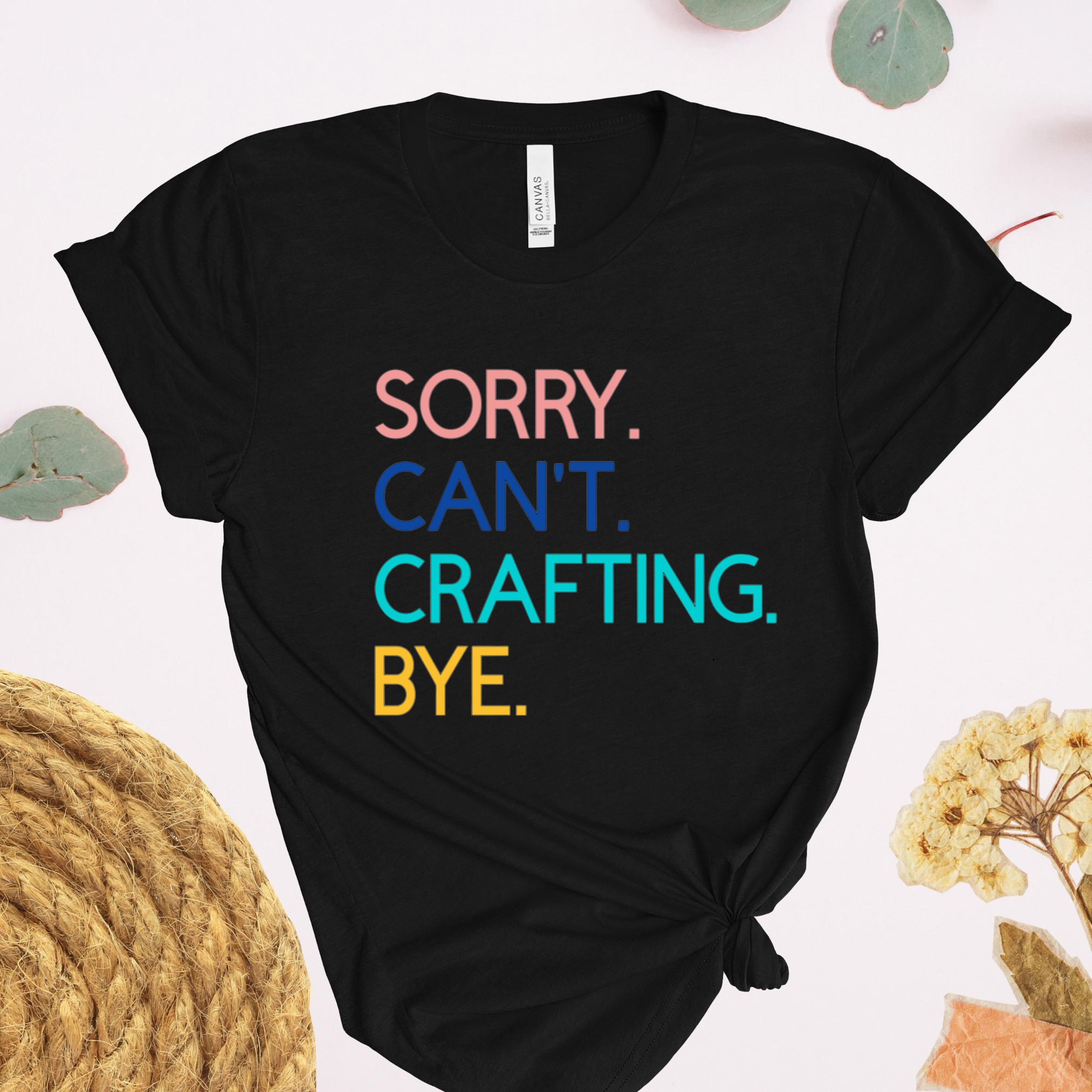 A black t-shirt with the text 'Sorry. Can't. Crafting. Bye.', each line with a different color text.