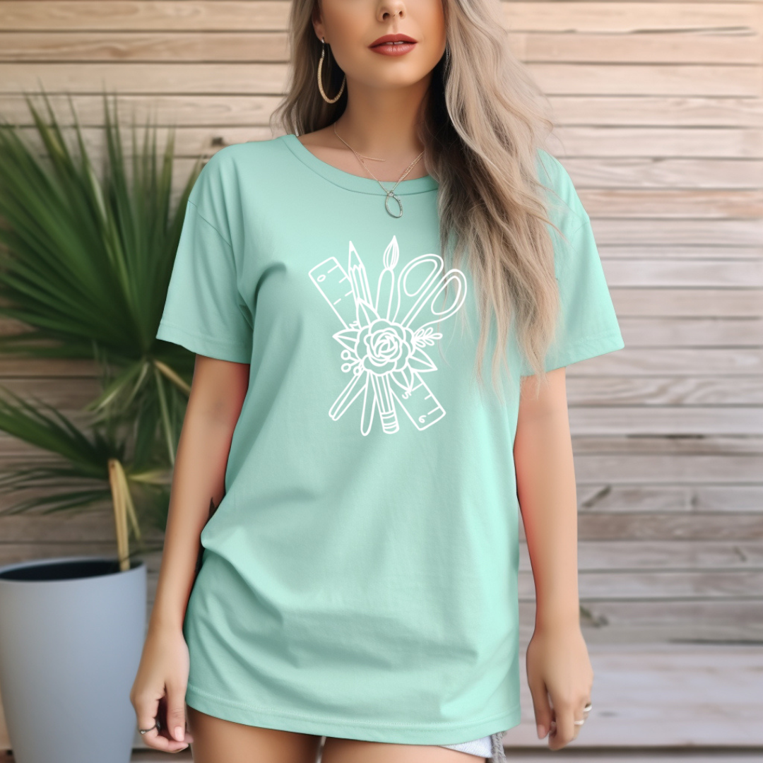 Woman wearing a light green t-shirt with a white graphic design against a wooden background
