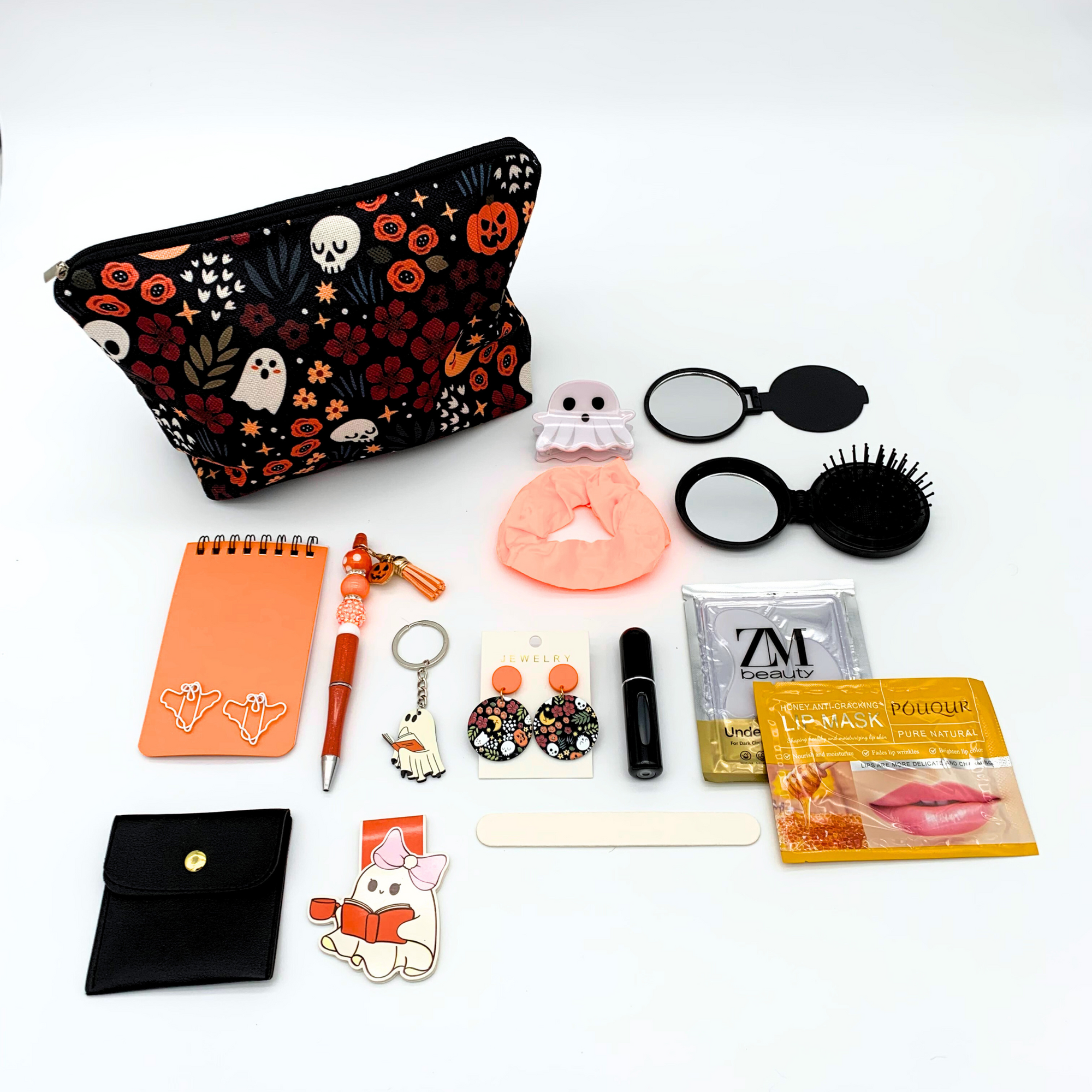 Collection of small items including a floral pouch, notepad, and various accessories on a white background