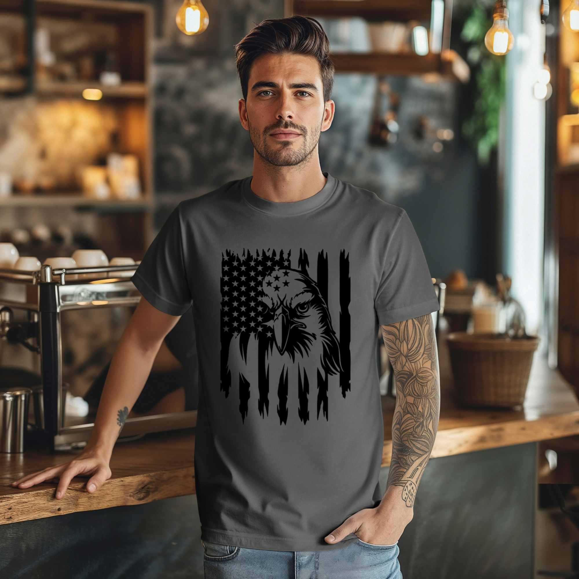Man wearing a gray t-shirt with an eagle and flag design in a coffee shop.