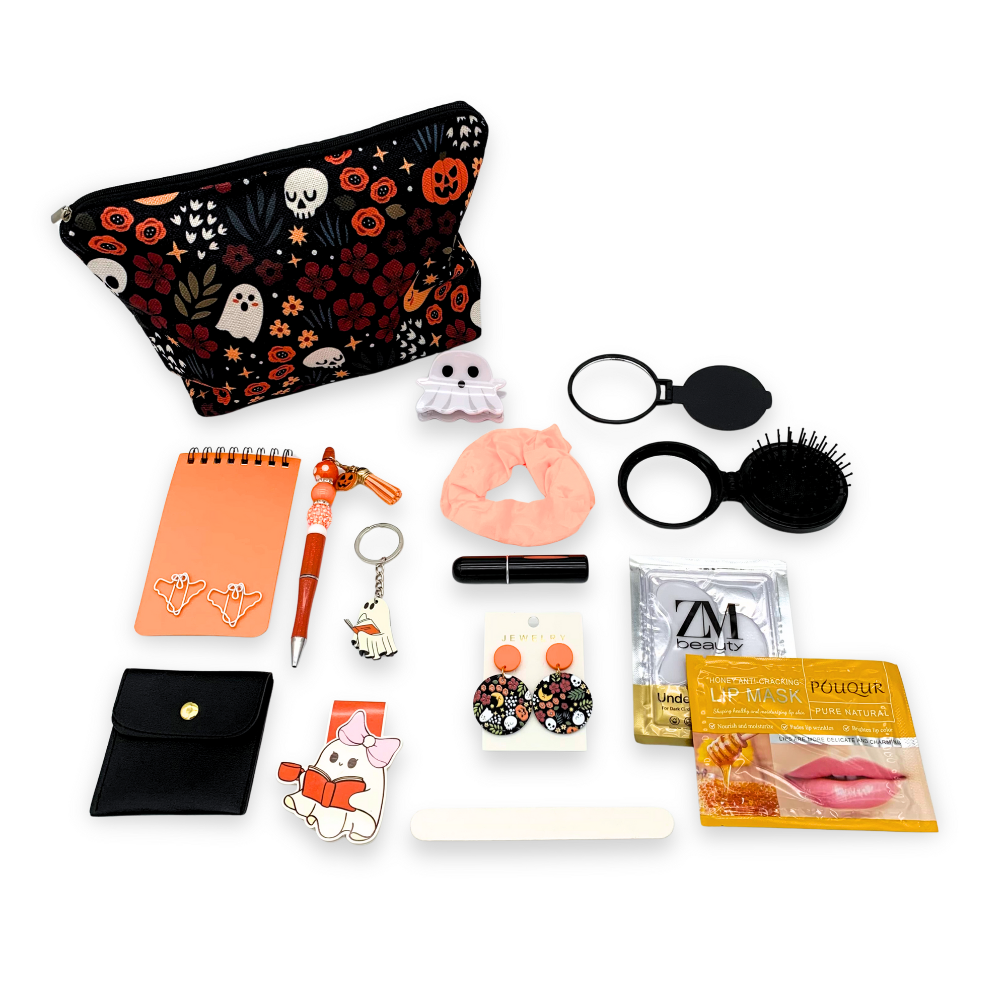 Collection of small items including a pouch with Halloween design, notebook, pen, keychain, and other accessories on a white background.
