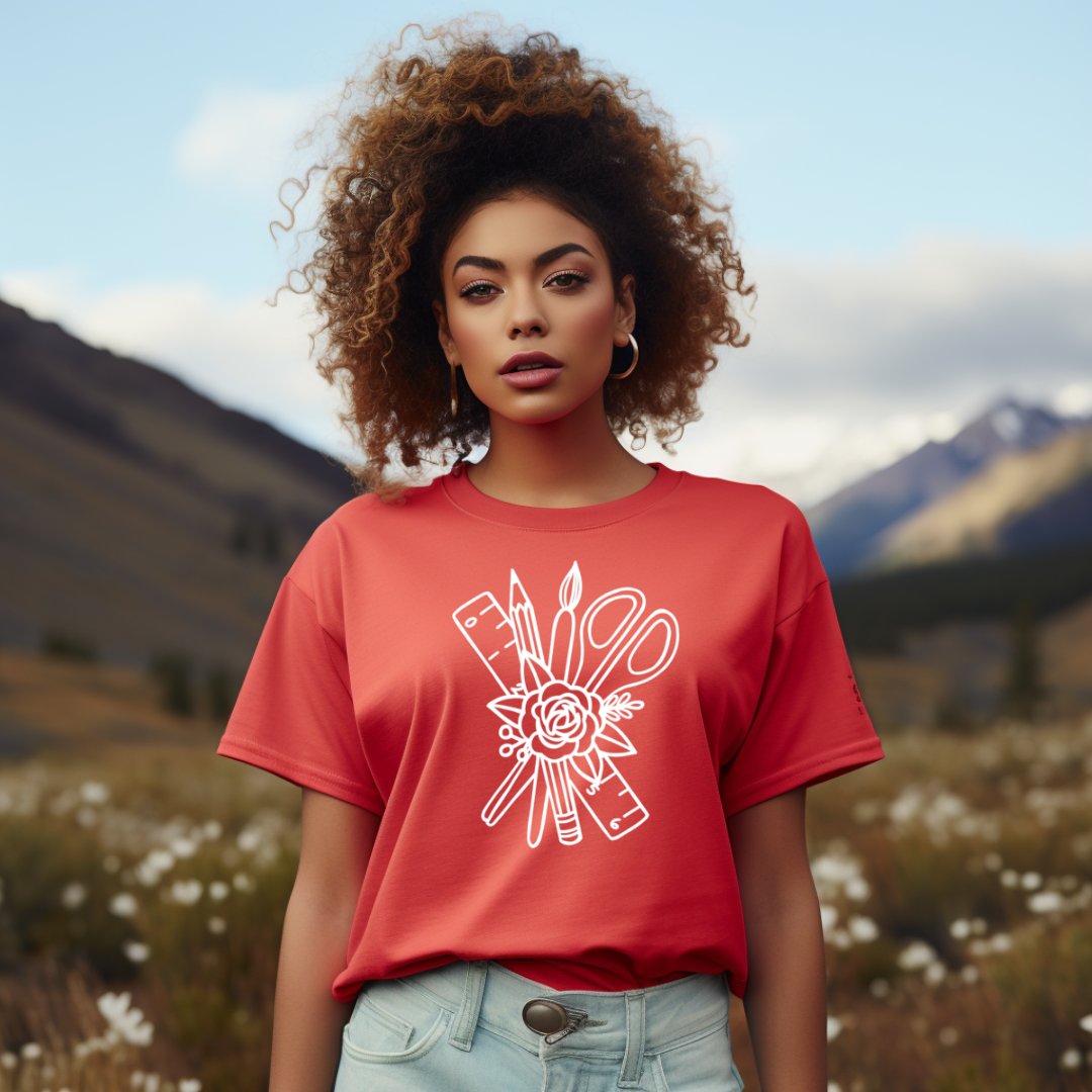 Woman wearing a red t-shirt with a white graphic design in a mountainous landscape