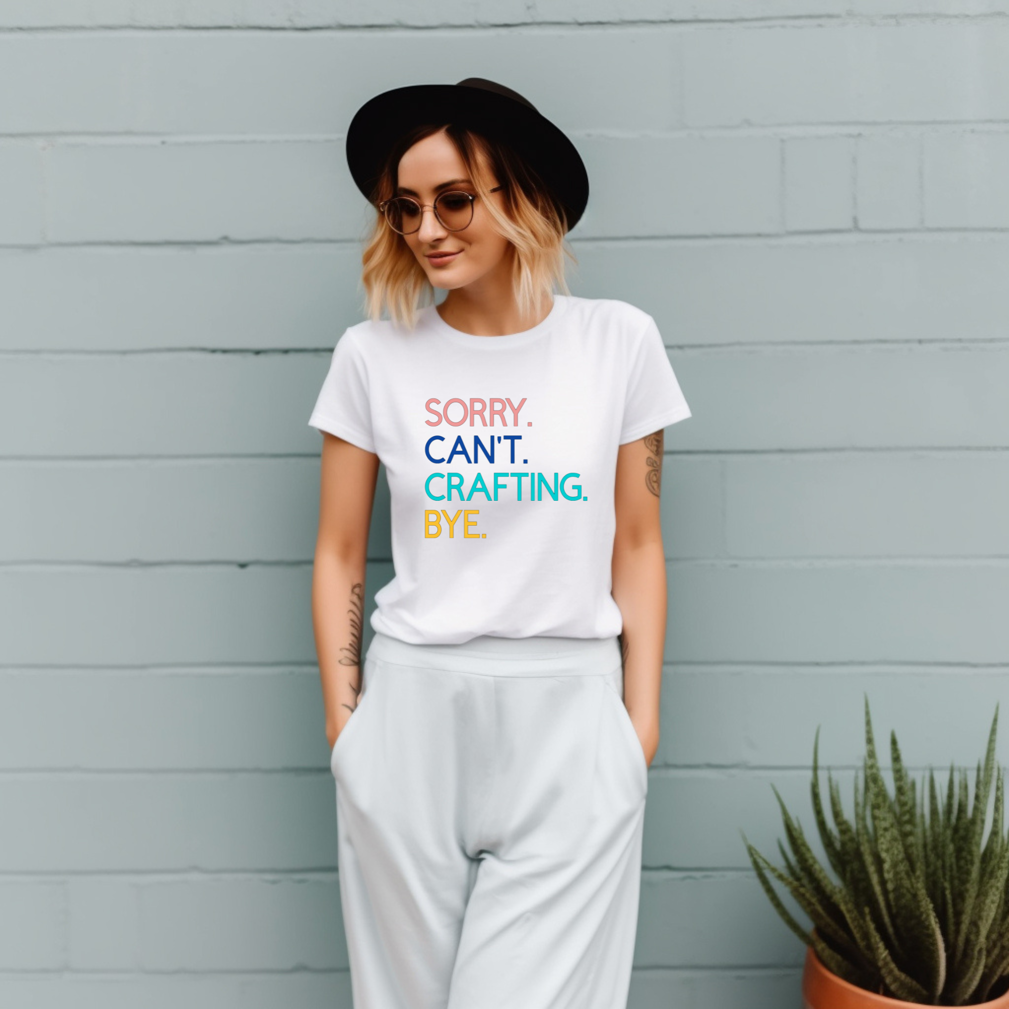 A woman in a white t-shirt with the text 'Sorry. Can't. Crafting. Bye.', each line with a different color text.