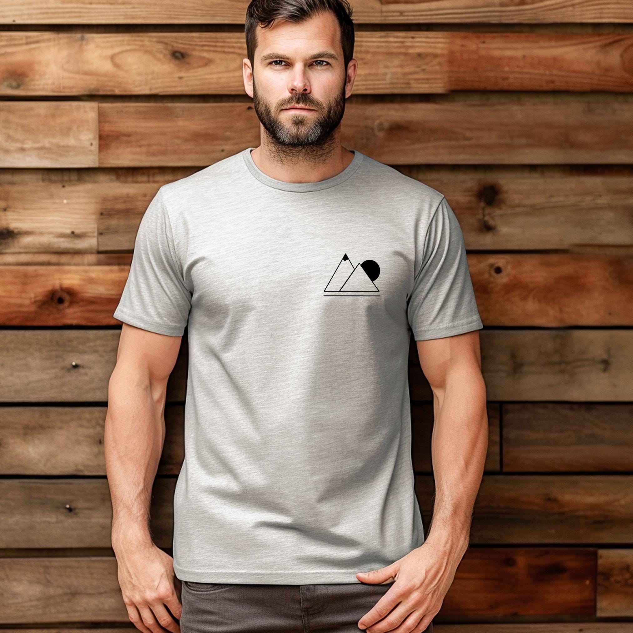 A person wearing a gray t-shirt with a simple geometric mountain silhouette on the front.