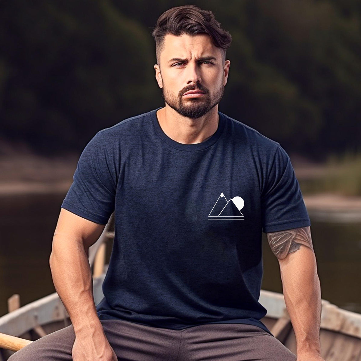 A person wearing a navy blue t-shirt with a simple geometric mountain silhouette on the front, sitting on a boat.