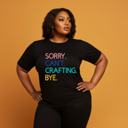 A woman in a black t-shirt with the text 'Sorry. Can't. Crafting. Bye.', each line with a different color text.