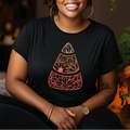 Woman wearing a black t-shirt with a geometric design, sitting in a room with plants.