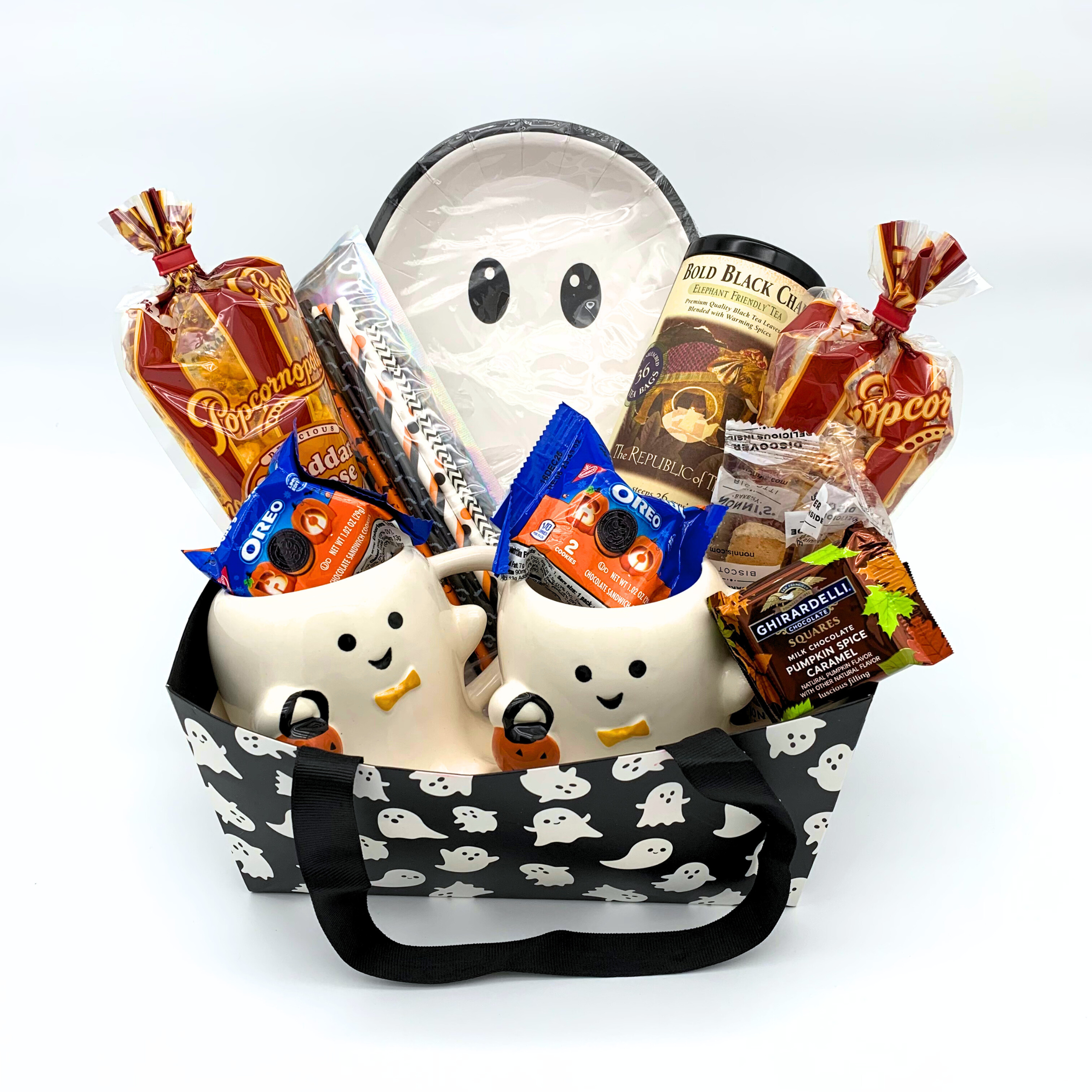 Halloween-themed gift basket with ghost designs and candy on a white background