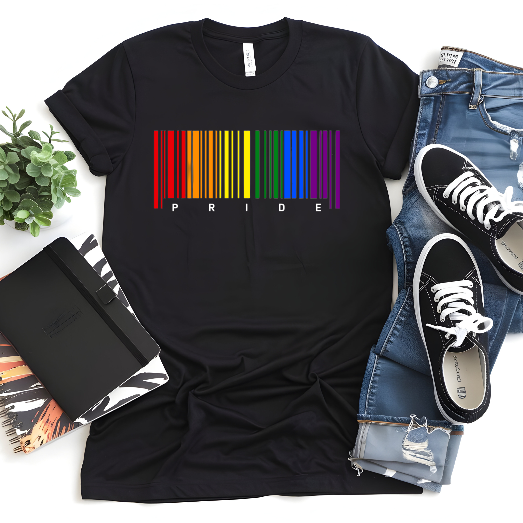Black t-shirt with rainbow 'PRIDE' design, jeans, sneakers, and a plant on a white surface.
