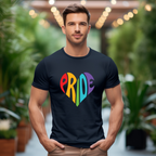 Man wearing a black t-shirt with 'PRIDE' in colorful letters, standing in a blurred indoor setting with plants.