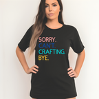 A woman in a black t-shirt with the text 'Sorry. Can't. Crafting. Bye.', each line with a different color text.