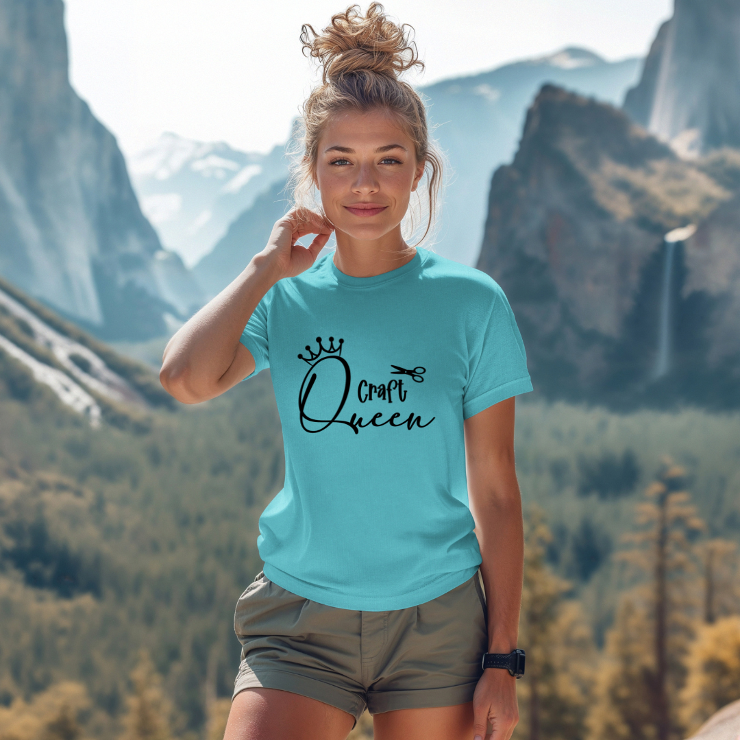 Woman wearing a turquoise t-shirt with 'Craft Queen' text in a mountainous landscape