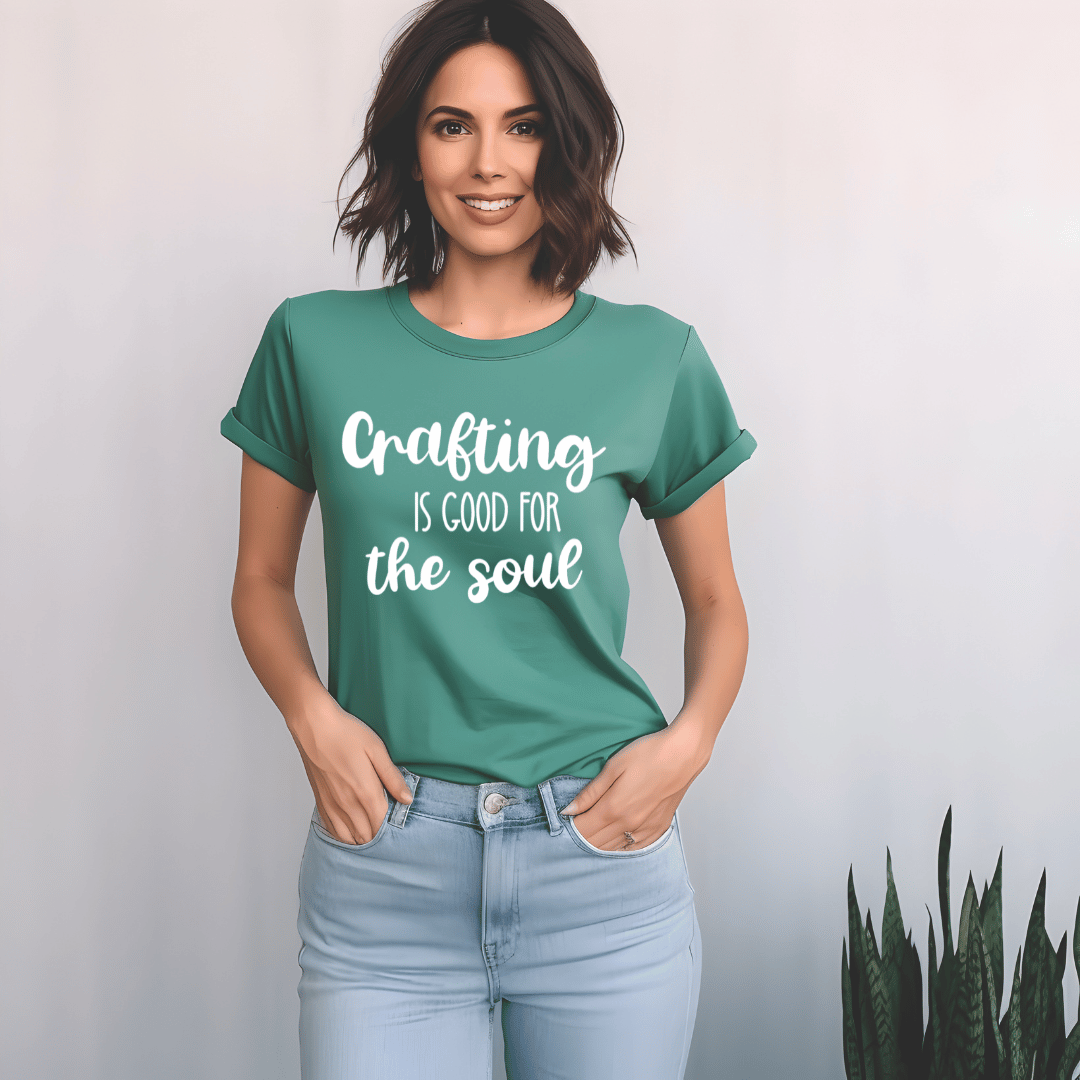 Woman wearing a green t-shirt with 'Crafting is good for the soul' text on a plain background