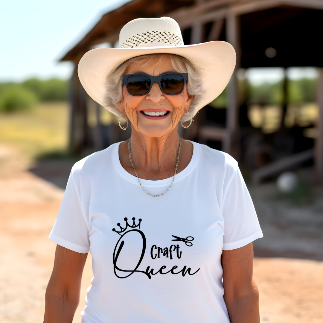 Woman wearing a white t-shirt with 'Craft Queen' design and a sun hat outdoors.