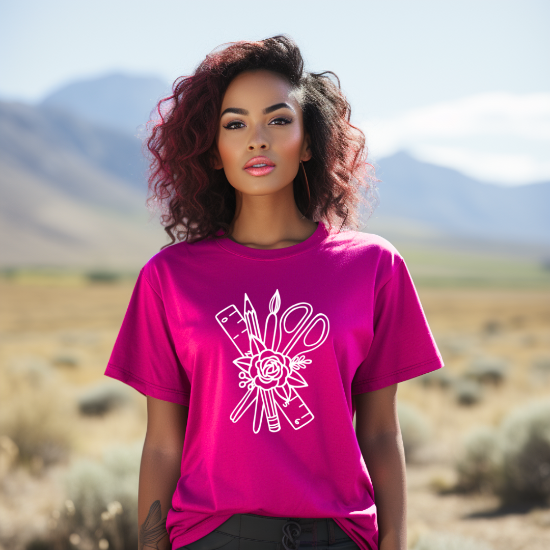 Woman wearing a pink t-shirt with a white graphic design in a desert setting