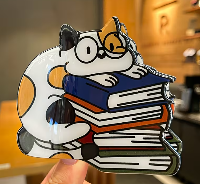 Cartoon cat holding books with a blurred indoor background