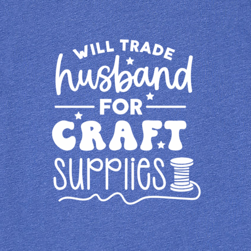 Blue t-shirt with white text 'WILL TRADE HUSBAND FOR CRAFT SUPPLIES' on a blue background