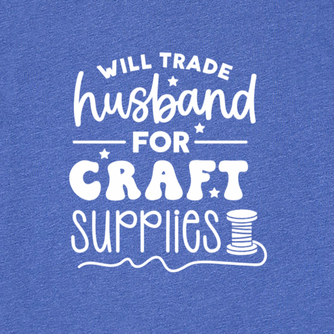 Blue t-shirt with white text 'WILL TRADE HUSBAND FOR CRAFT SUPPLIES' on a blue background