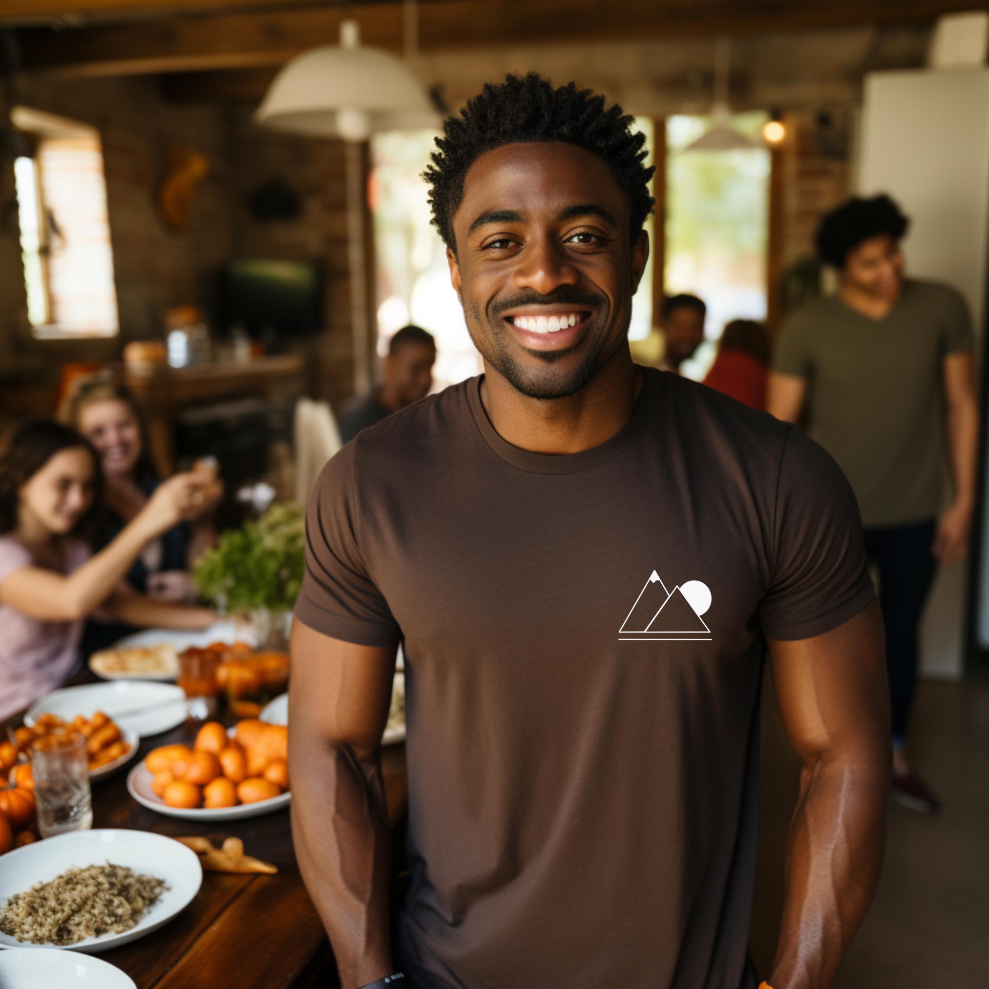 A person wearing a brown t-shirt with a simple geometric mountain silhouette on the front.