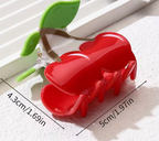 Red hair clip with green leaves on a white surface, showing measurements.