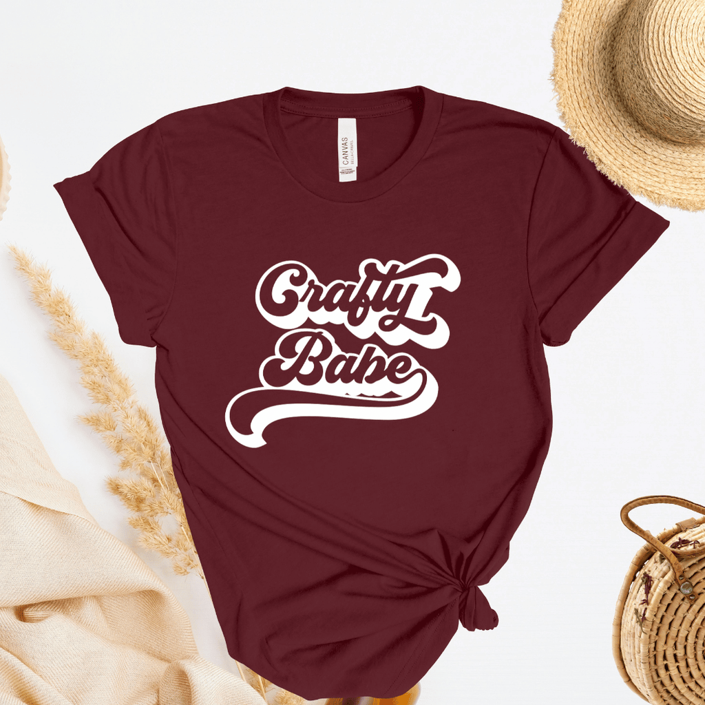 Maroon t-shirt with 'Crafty Babe' text on a light background