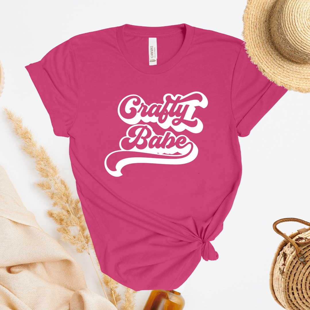Pink t-shirt with 'Crafty Babe' text on a white background