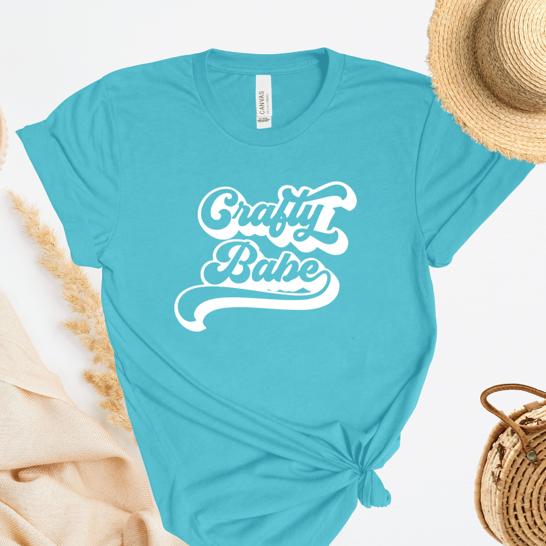 Turquoise t-shirt with 'Crafty Babe' text on a white background