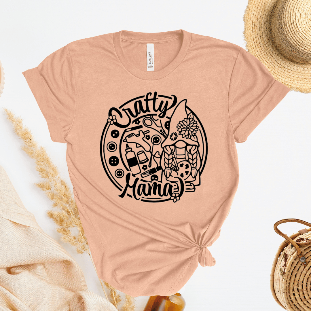 Peach t-shirt with 'Crafty Mama' graphic design on a light background