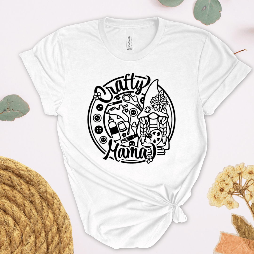 White t-shirt with 'Crafty Mama' design with buttons and craft supplies.