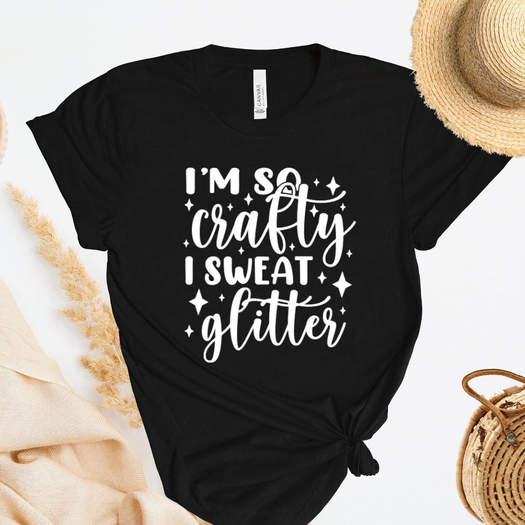 Black t-shirt with 'I'm so crafty I sweat glitter' text on a light background