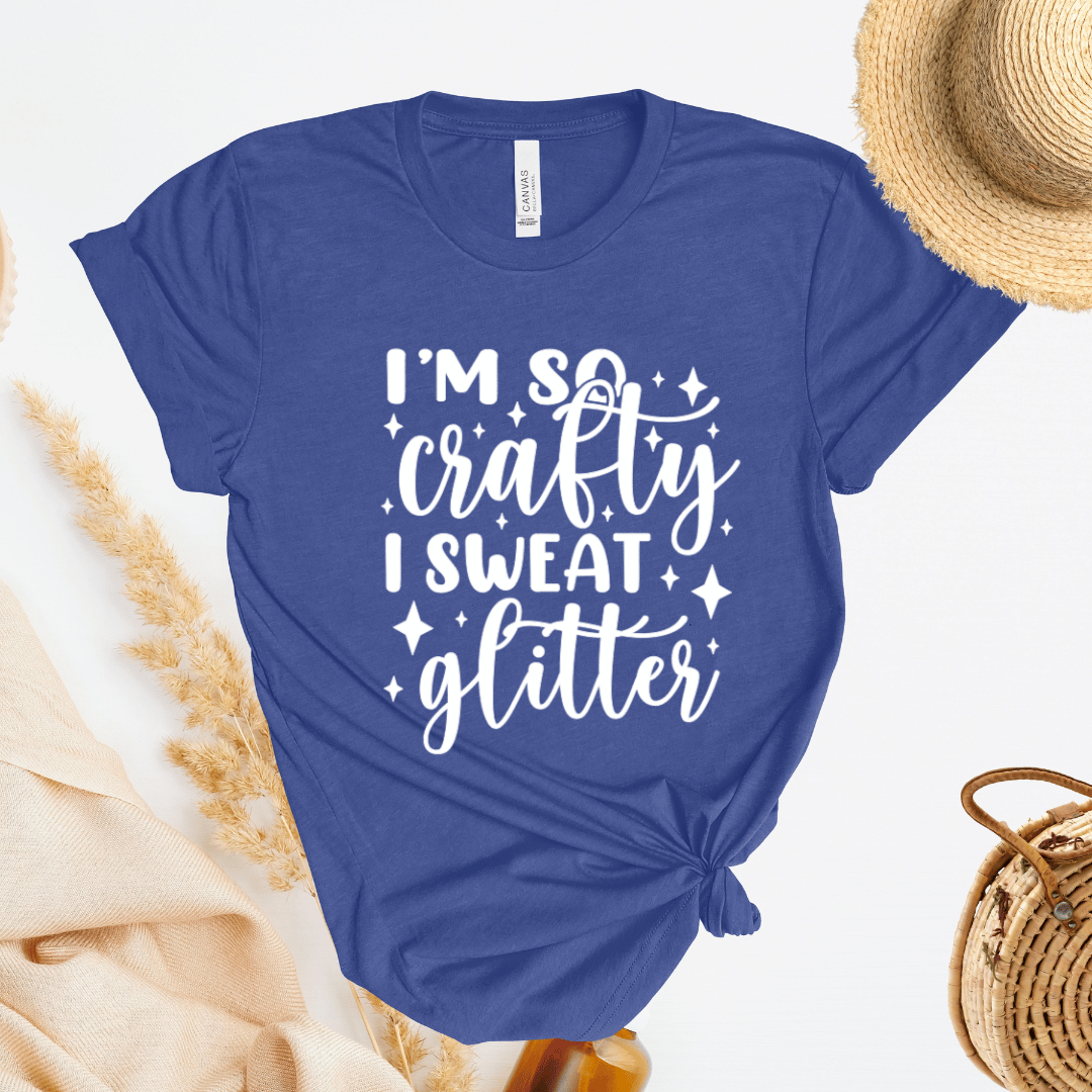 Blue t-shirt with 'I'm so crafty I sweat glitter' text on a light background