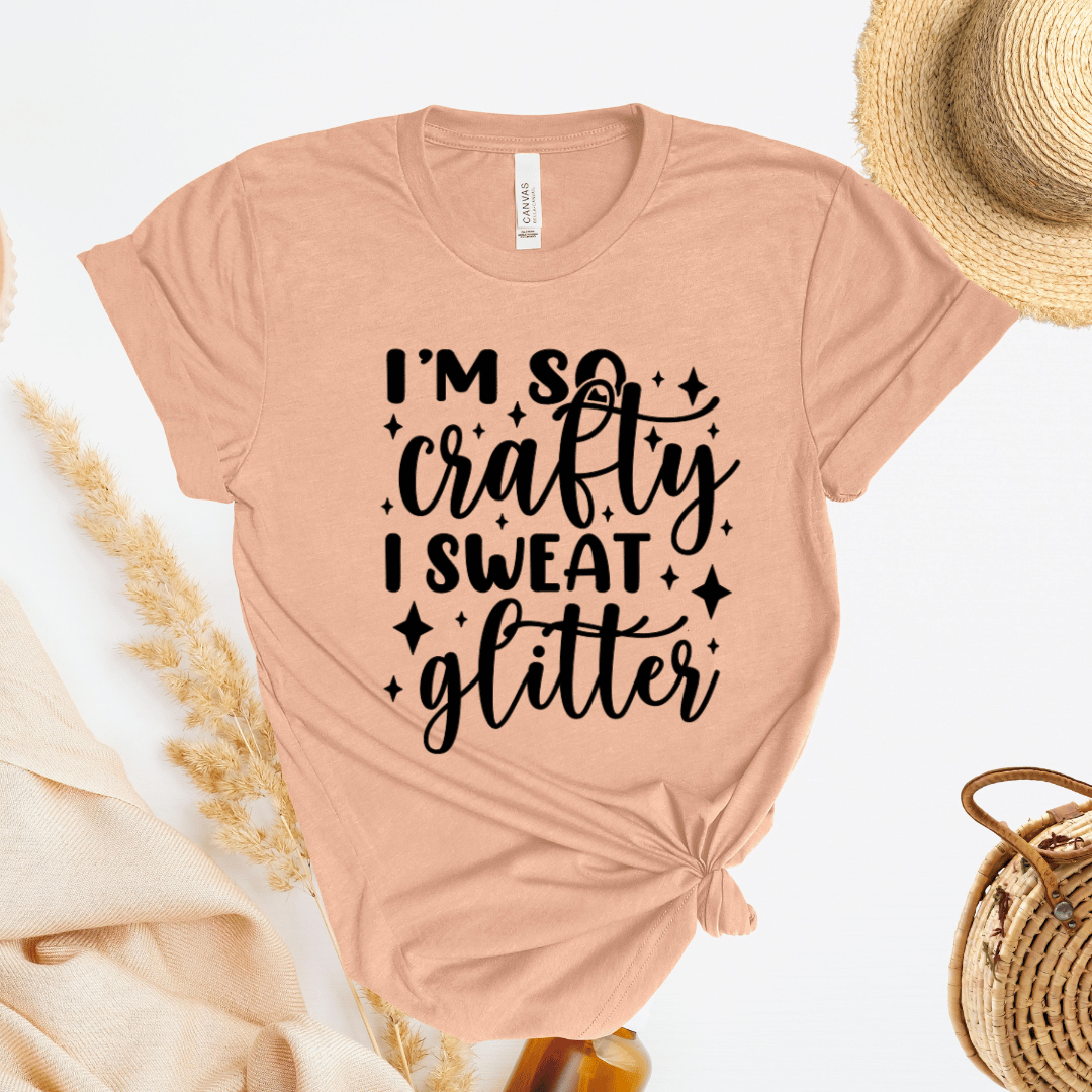 Beige t-shirt with 'I'm so crafty I sweat glitter' text on a light background