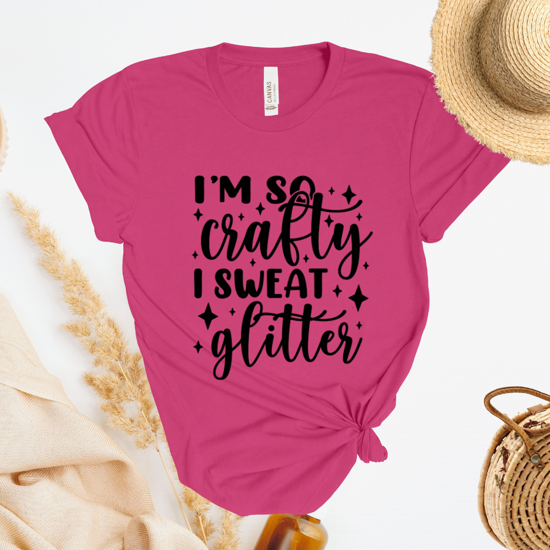Pink t-shirt with 'I'm so crafty, I sweat glitter' text on a white background