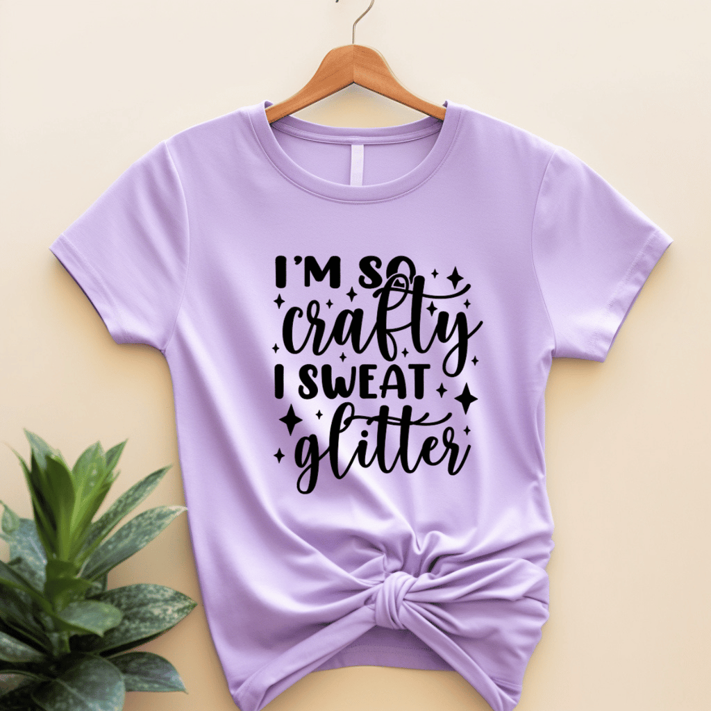 Purple t-shirt with 'I'm so crafty I sweat glitter' text on a beige background
