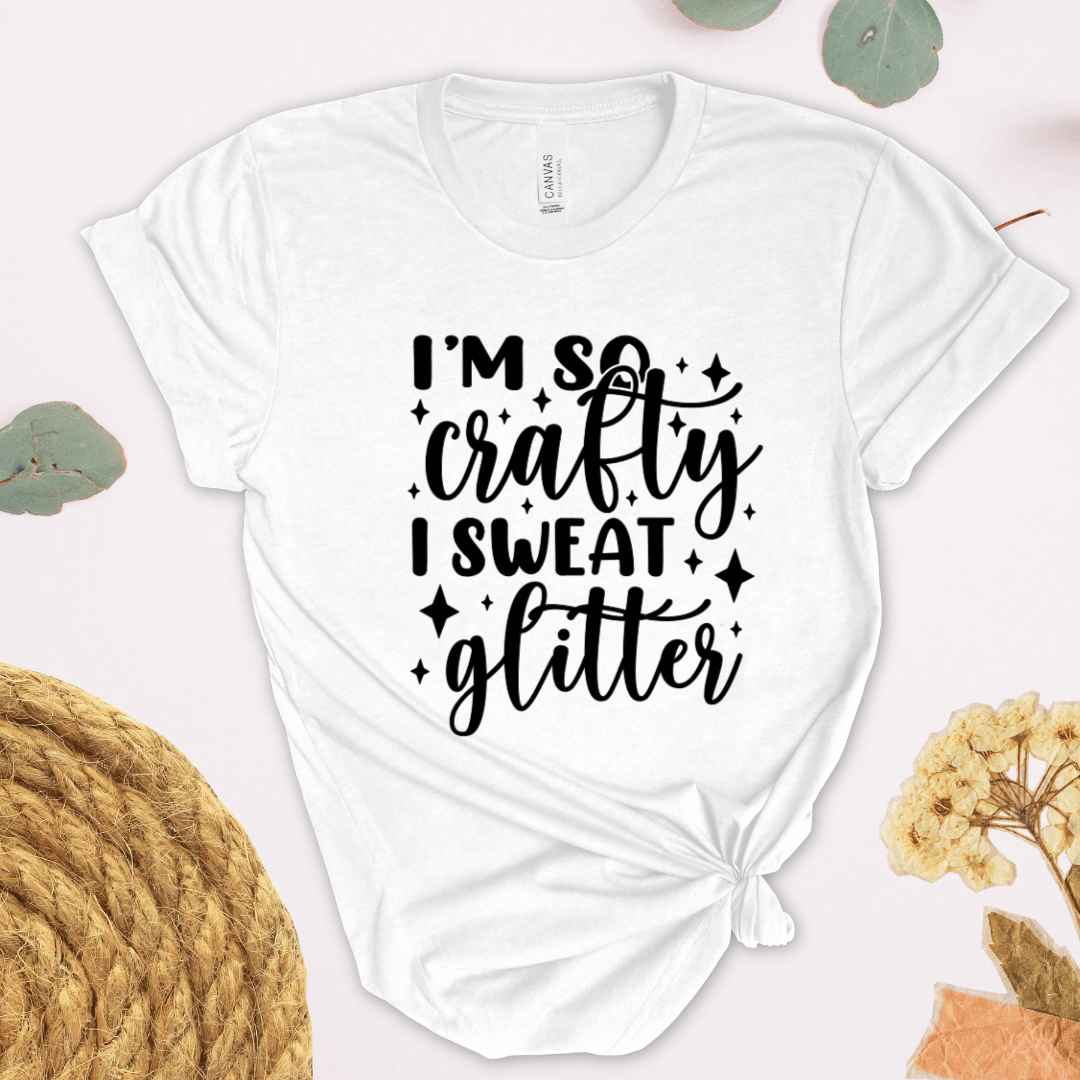 White t-shirt with 'I'm so crafty I sweat glitter' text on a light background