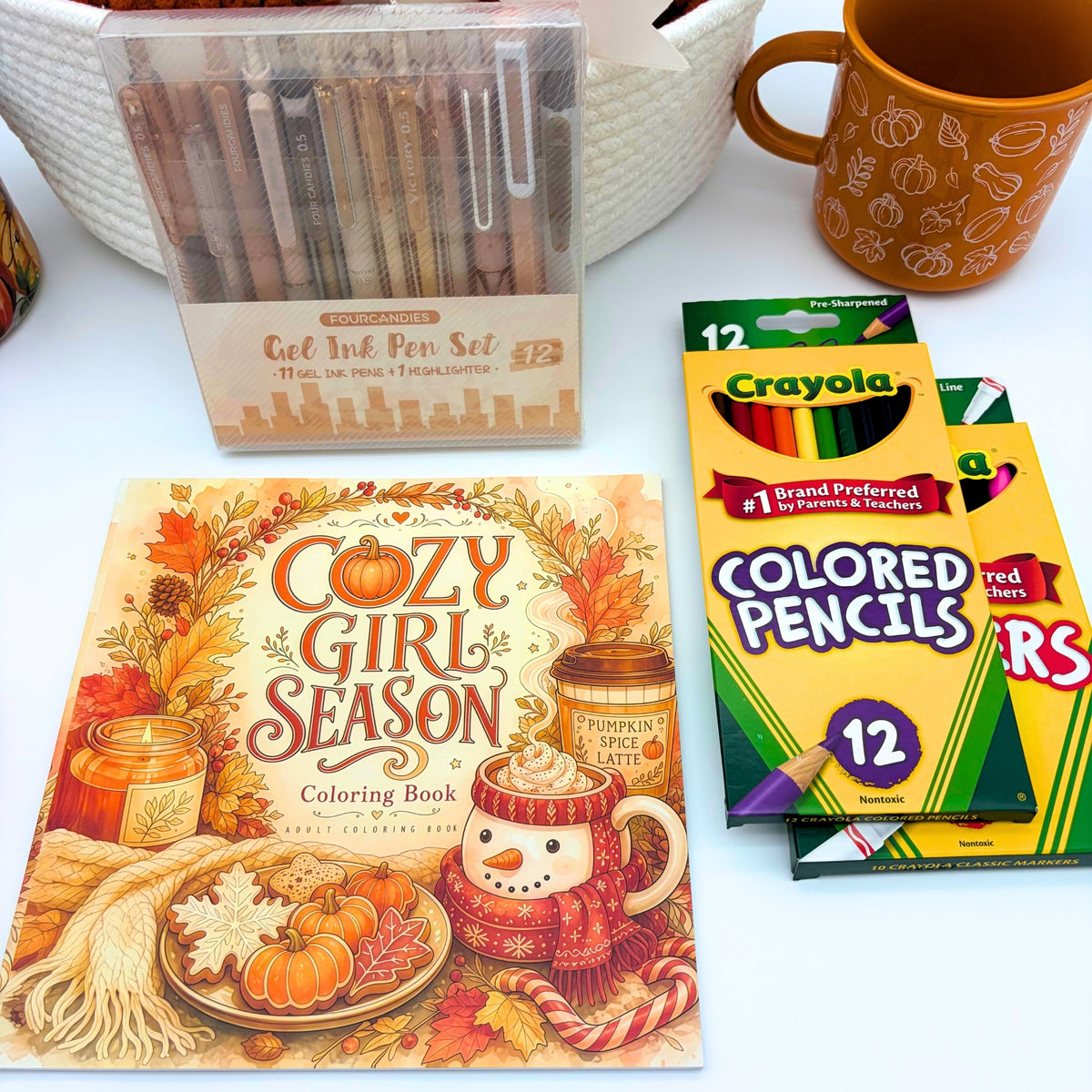 Cozy Girl Season adult coloring book cover with an autumn leaf wreath and pumpkin spice latte, beside colored pencils and gel pens