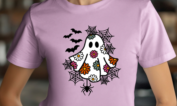 Purple t-shirt with a Halloween-themed design featuring a ghost, flowers, and spiders.