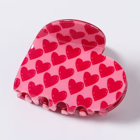 Heart-shaped hair claw clip with red hearts pattern on pink glossy base