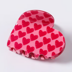 Heart-shaped hair claw clip with red hearts pattern on pink glossy base