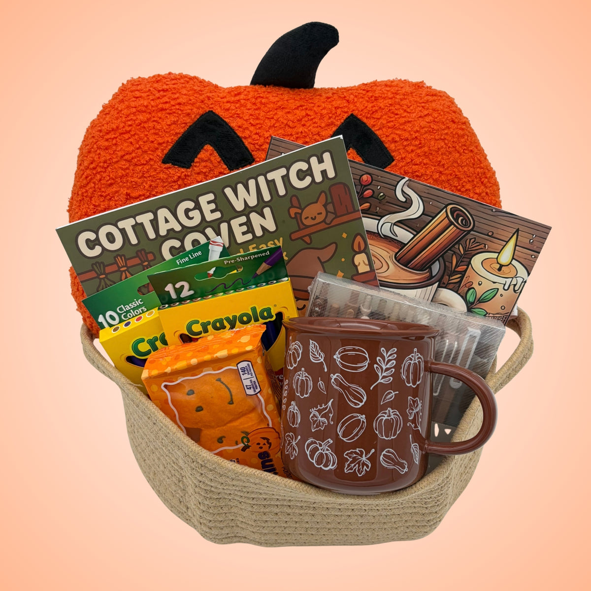 Jack-o'-lantern coloring book gift set in a tan rope basket with an orange pumpkin pillow, two coloring books, brown mug, and markers