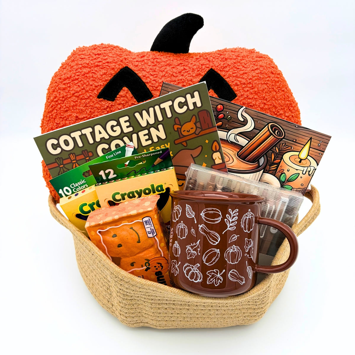 Halloween pumpkin coloring gift basket with a jack-o'-lantern pillow, two coloring books, brown fall mug, and marshmallow pumpkins